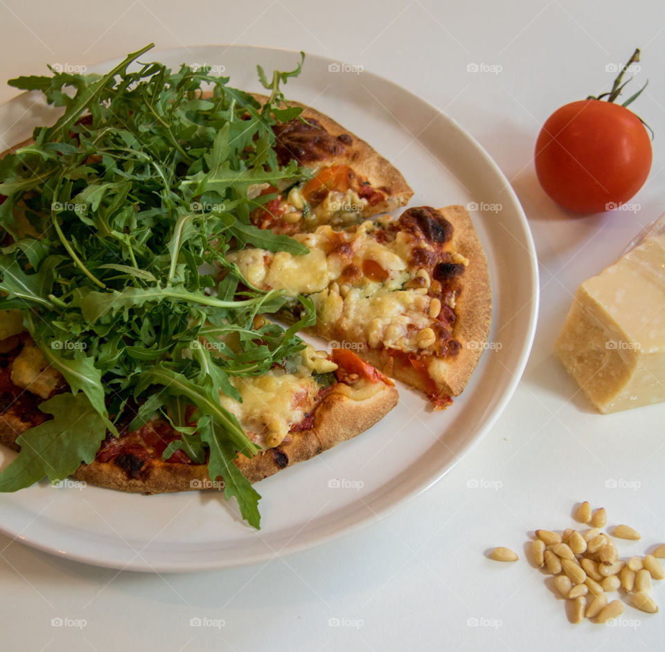 Hot pizza fresh out of the oven topped with arugula 