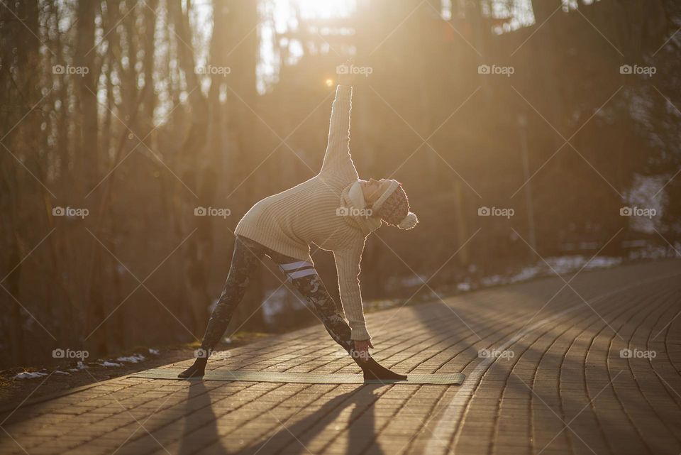 Young woman doing yoga exercises outdoor