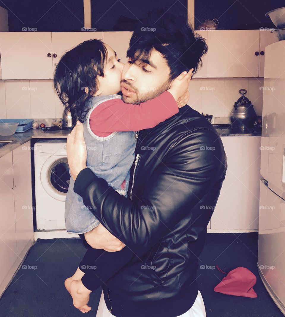 Cute daughter kissing father