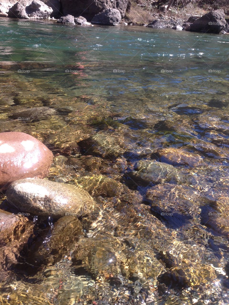At the river, in the sunlight. Glittering water and sparkling rocks. 