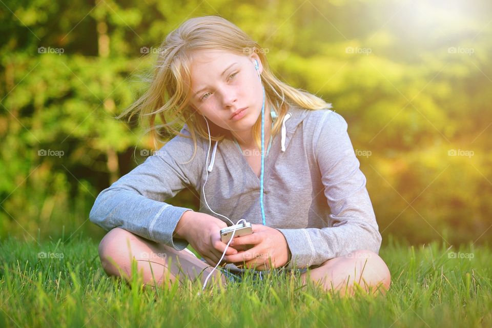 Musictime. Girl listens to music during golden hour