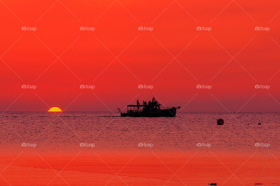 Boat sailing in sea at the time of sunset