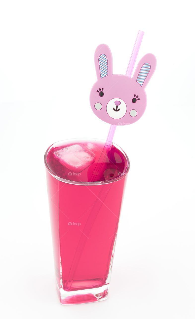 Glass of pink lemonade  with ice blocks and rabbit novelty straw.