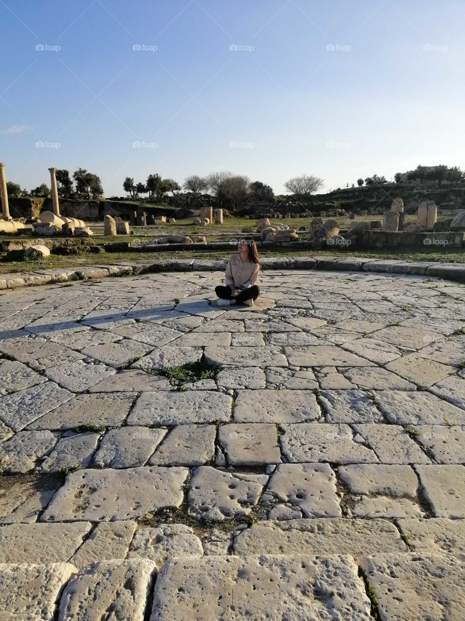The girl sitting on the stones of the ancient city