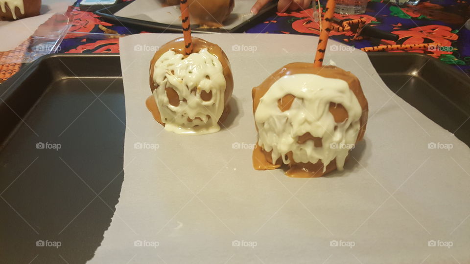 Two caramel apples sag when set too hot for a Halloween treat.