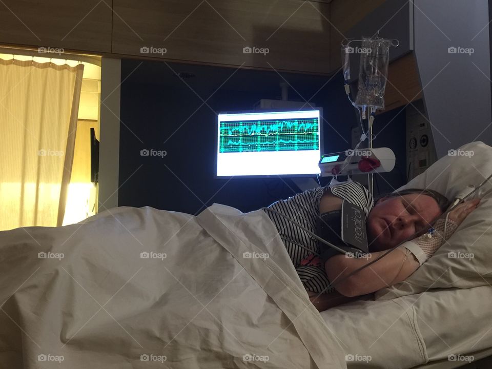 Woman sleeping on a medical bed in hospital ward