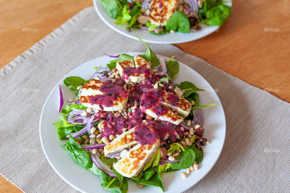 Cypriot halloumi grilled cheese salad with a dollop of blueberry sauce.