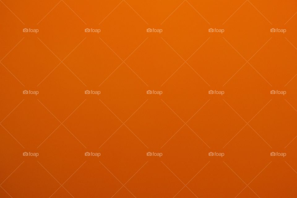 A closeup of an orange colored inflated  balloon.