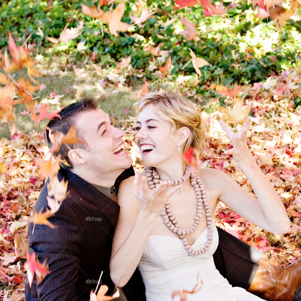 Couple laughing in fall leaves
