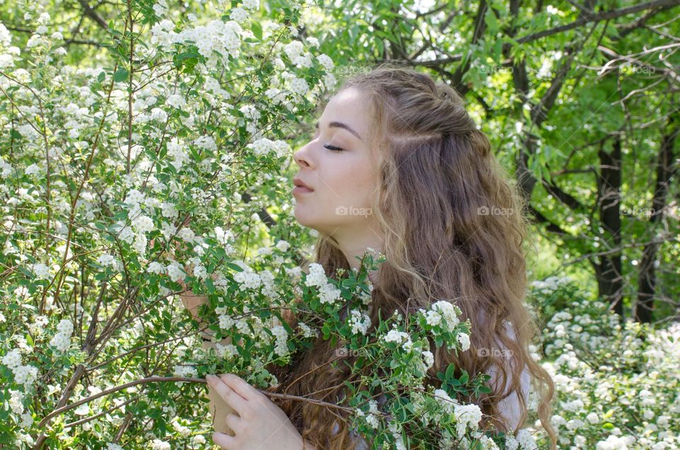 Portrait of Beautiful Young Girl on Flowers Background