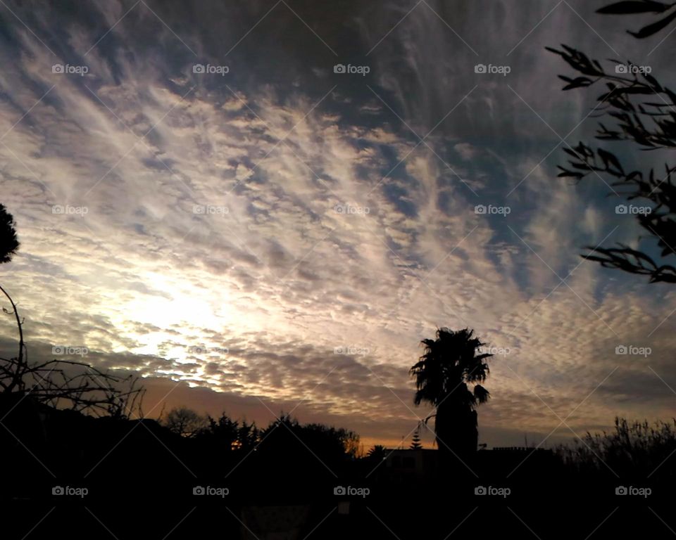Sunset with scattered clouds flavoured by a blend of silver and gold tones in Panza on the Italian island of Ischia