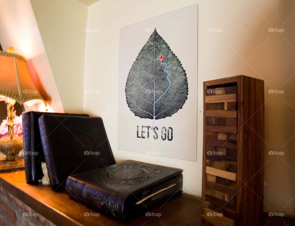 Let’s go motivation words next to leather bound books on shelf Displate Art home decor 