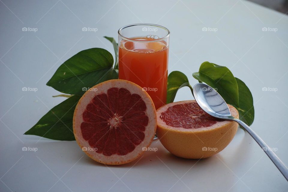 Healthy breakfast with fruit and juice , diet , orange juice , green leaves, grapefruit , spoon