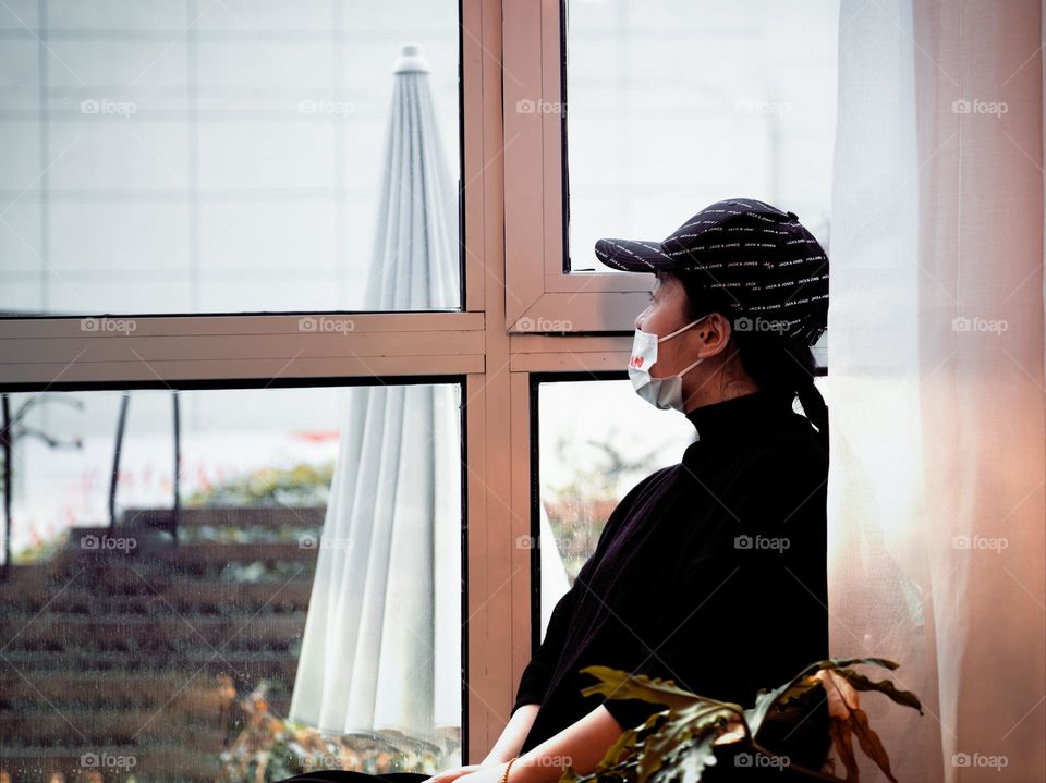 A woman is enjoying the view from the window.