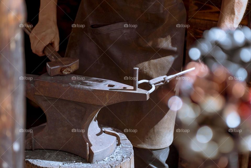 The blacksmith forges a horseshoe.  Forging machine close-up.