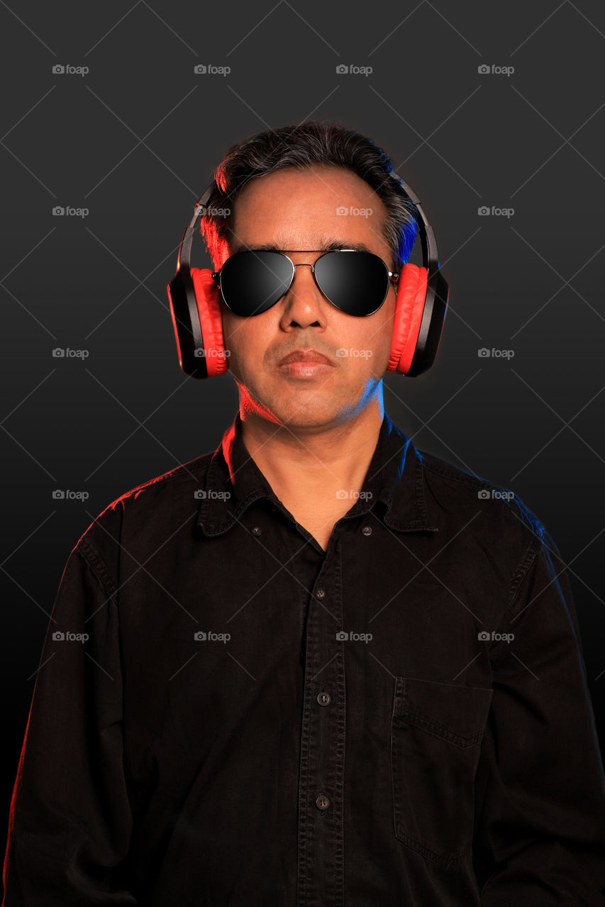 Indian man with Bluetooth headphones and sunglasses