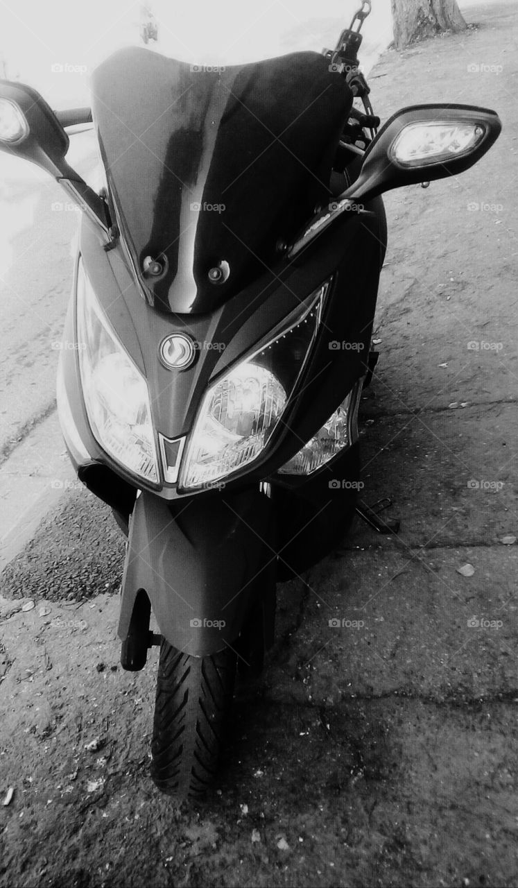 One motorcycle parking on asphalt on
walkside in street in daylight