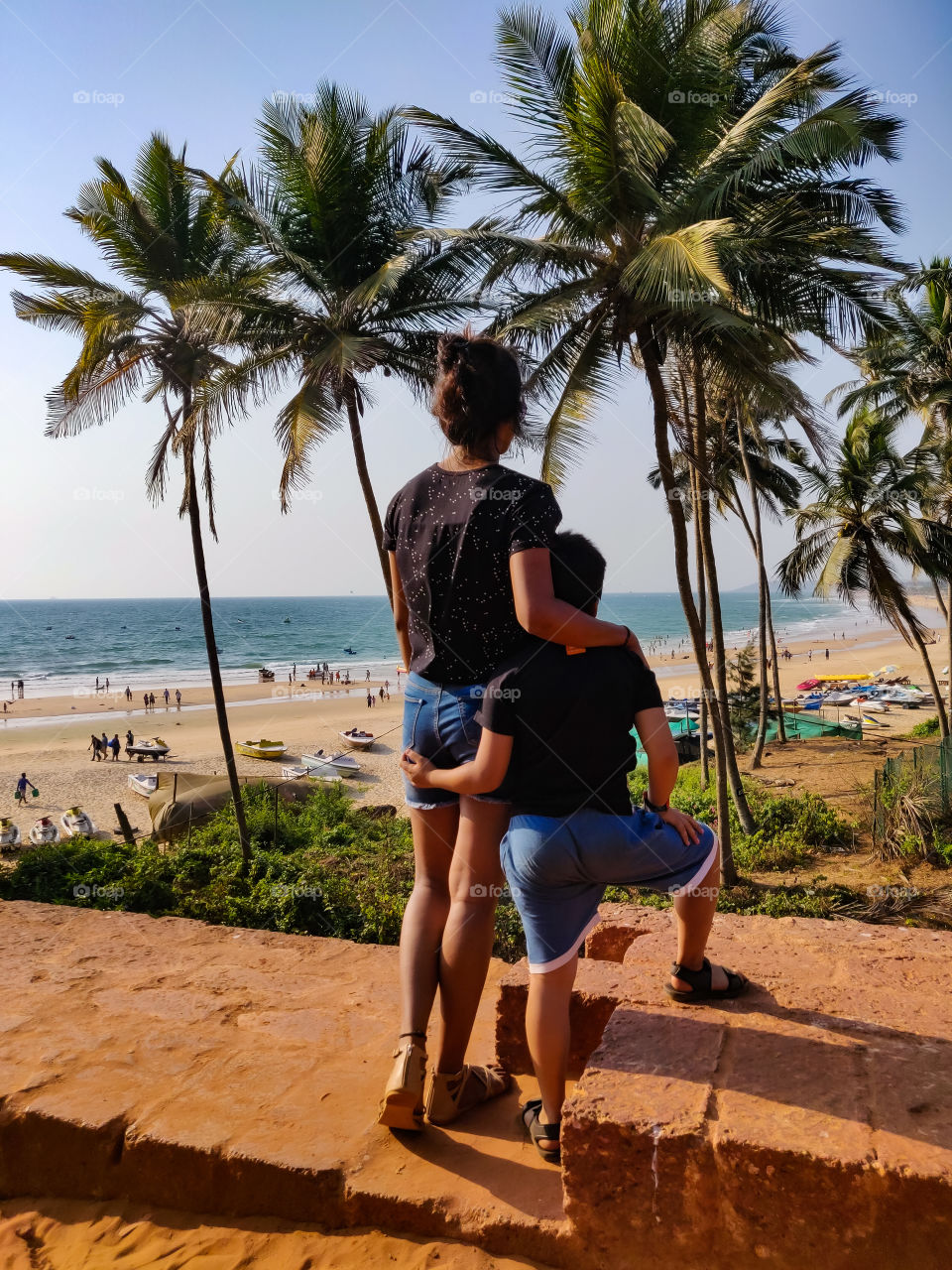 young woman with a small kid standing and watching the sea or beach from the top during her vacation