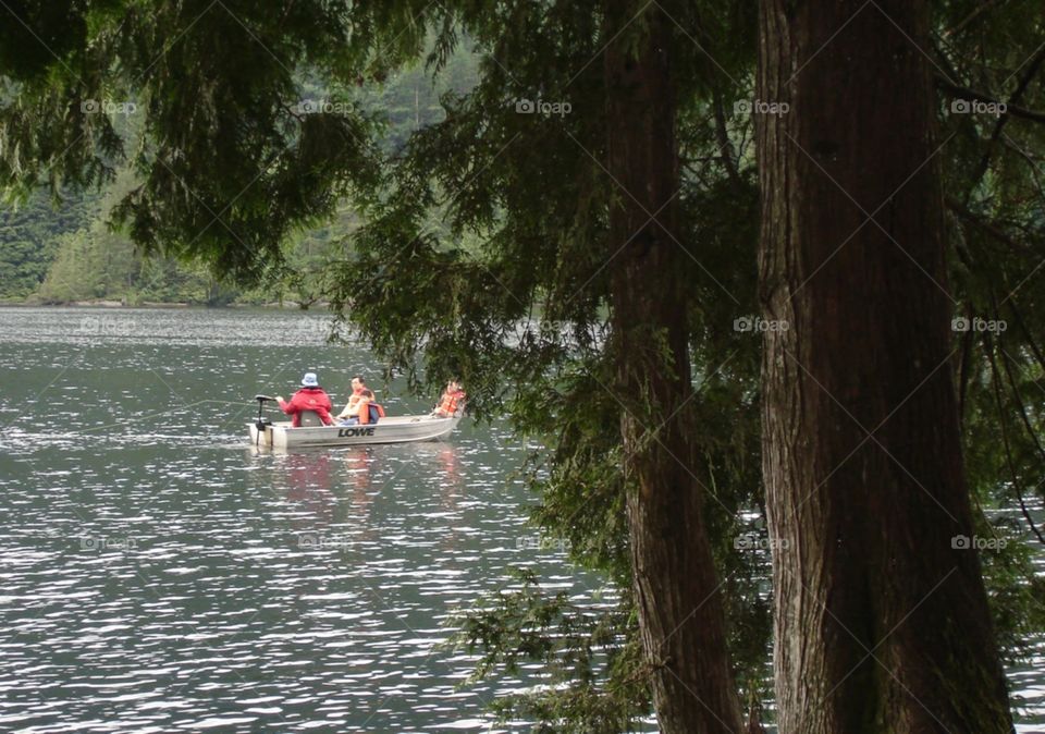 Several people touring the peaceful waters of Bunzten Lake on an Autumn day In British Columbia 
