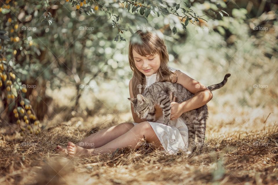 Children playing with kitten in a garden