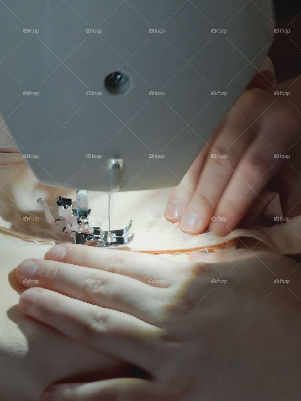 young woman making a dress on a sewing machine