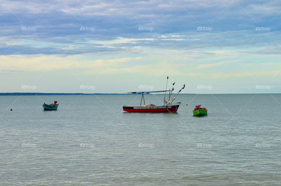 native boats on red crown beach Bahia Brazil