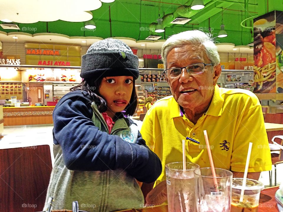 Grandfather with grandchild standing in restaurant
