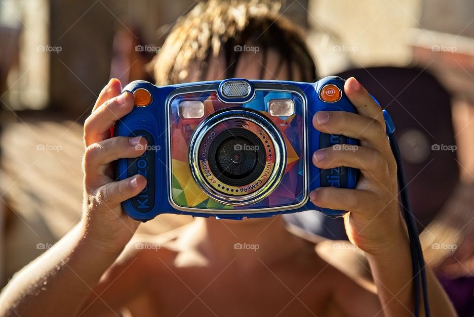 A boy takes a photo with his toy camera