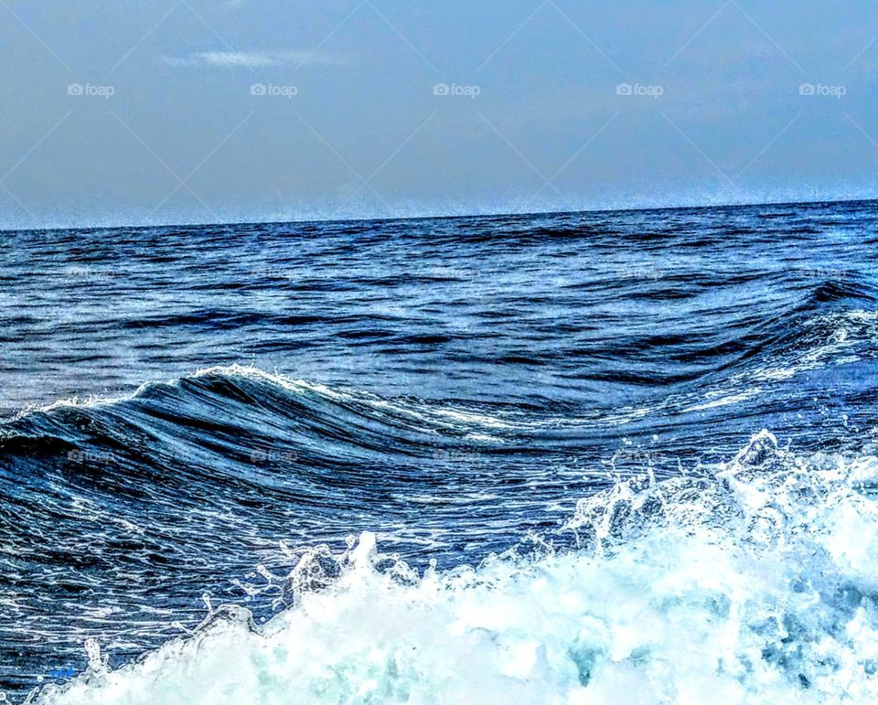 A close-up waves and sprays in the sea that are a rhythmic and splashing beauty. also looks peaceful.