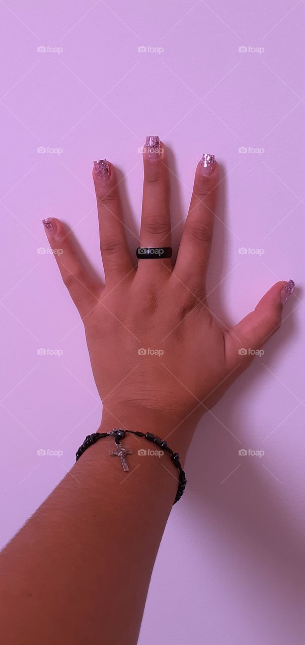 mão em uma parede rosa