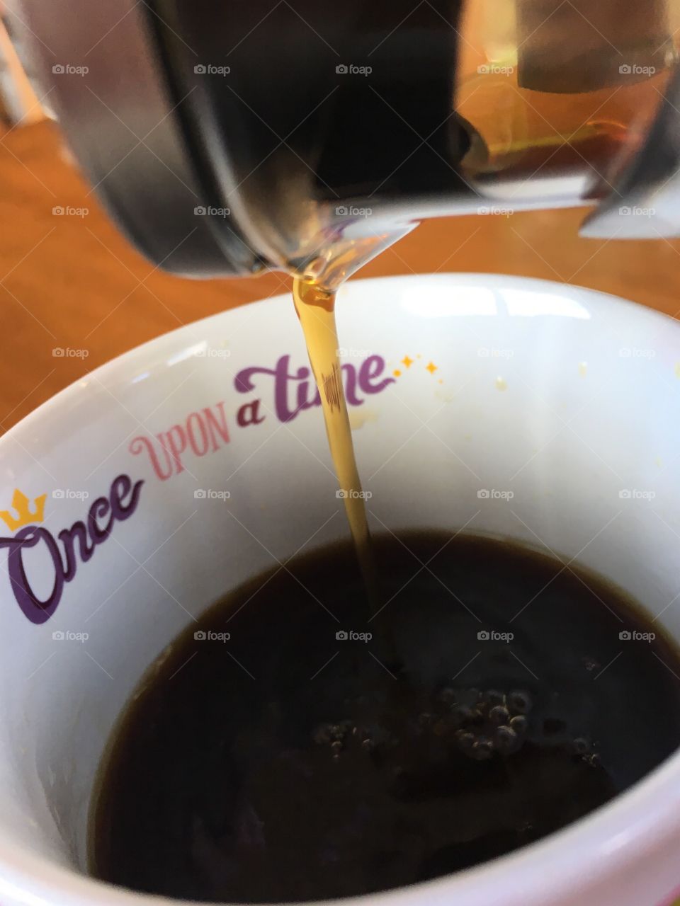 French press black coffee being poured into white ceramic mug that says 'once upon a time'