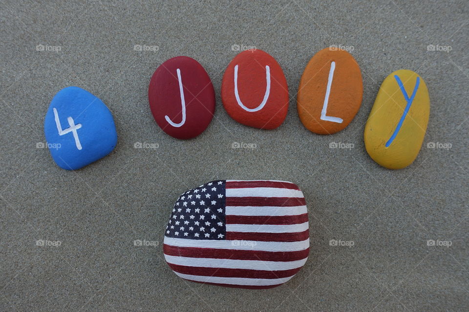 4 July, United States of America Independence day with multi colored stones over beach sand