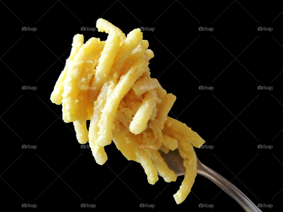 Macaroni and cheese isolated on black background.