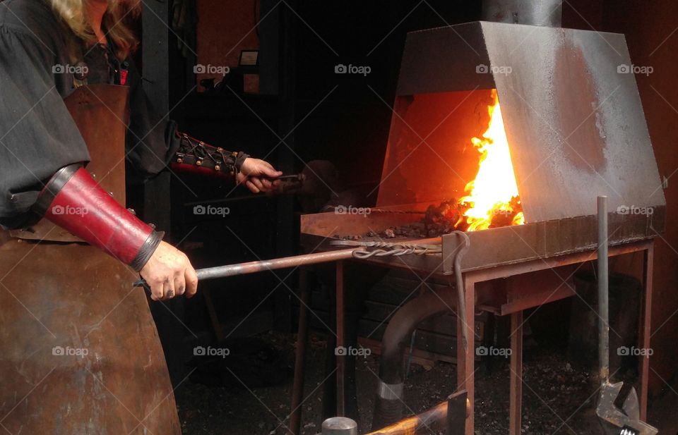 A blacksmith putting on a demonstration at the Ohio renaissance festival. Here we see him heating up a large iron rod in the forge. Unfortunatley I showed up late, and I didn't catch what he said he was making.