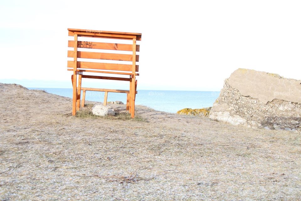 Lone bench facing the sea