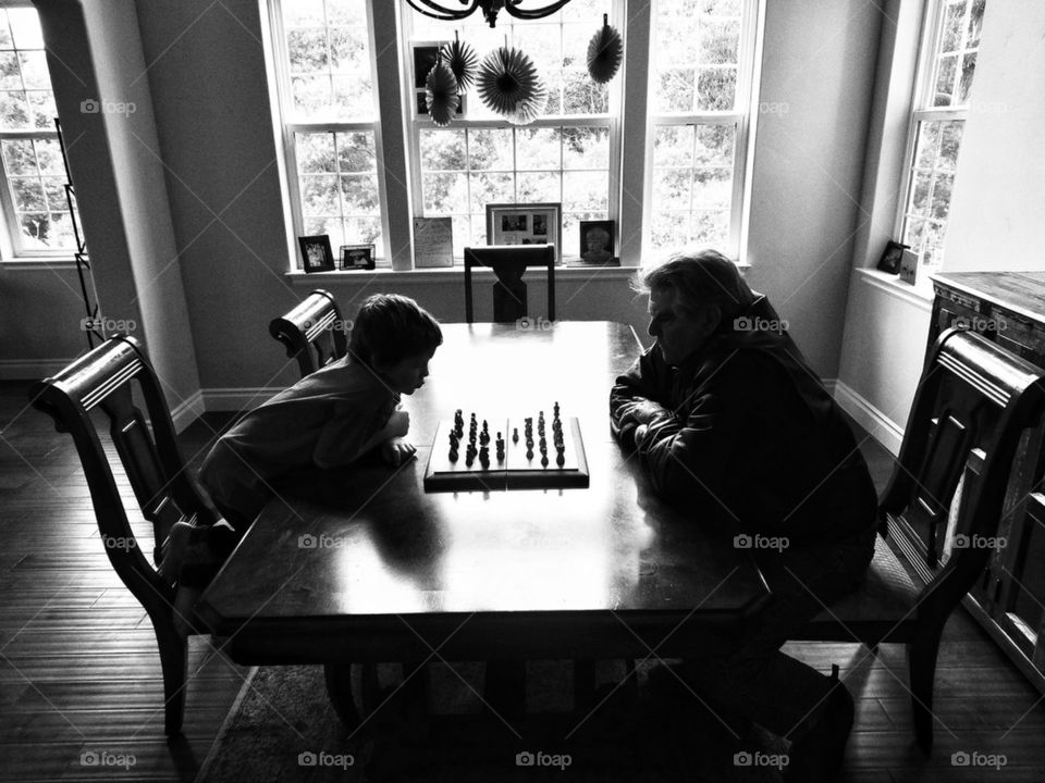 Young boy and his grandfather playing chess