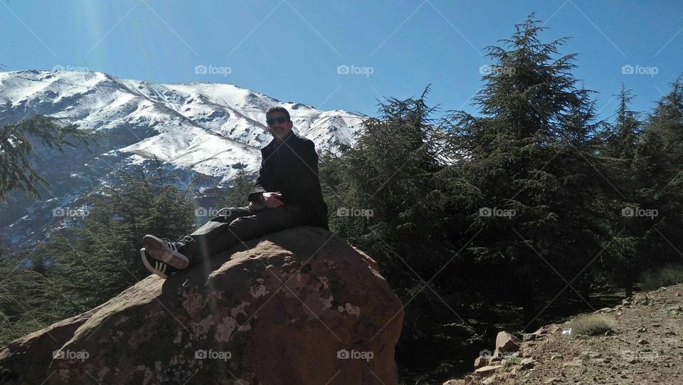 I m sitting on a rock in high mountain.