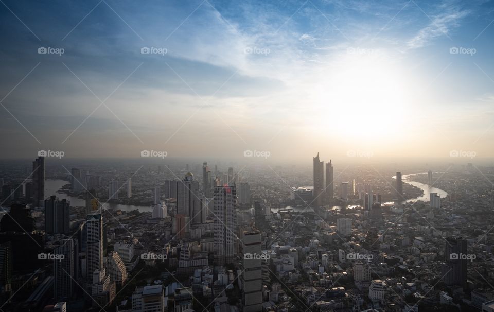 Beautiful light of Sunset shade over the Chao Phraya River and Building in the big city , take photo from MahaNakhon tower , Bangkok Thailand 