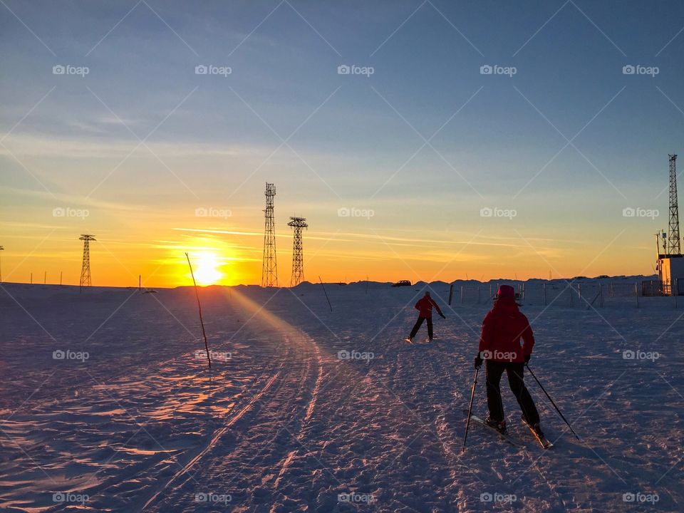 Group of people skiing at sunset