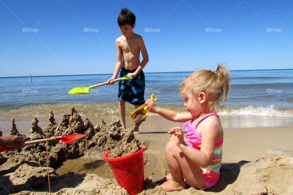 Family beach time . My niece and nephew playing in the sand 