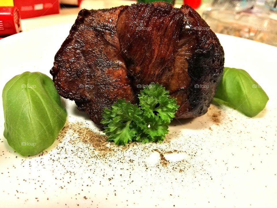 Steak with fresh herbs on a white background