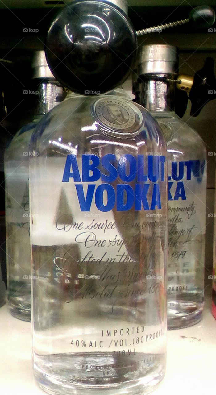Full glass bottle of ABSOLUT VODKA 
on shelf in store in clouseup