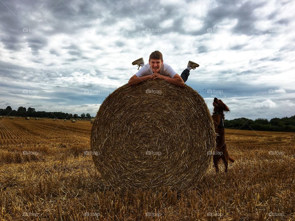 Pulling funny faces on top of a hay bale alongside an excited red setter joining in the fun ...