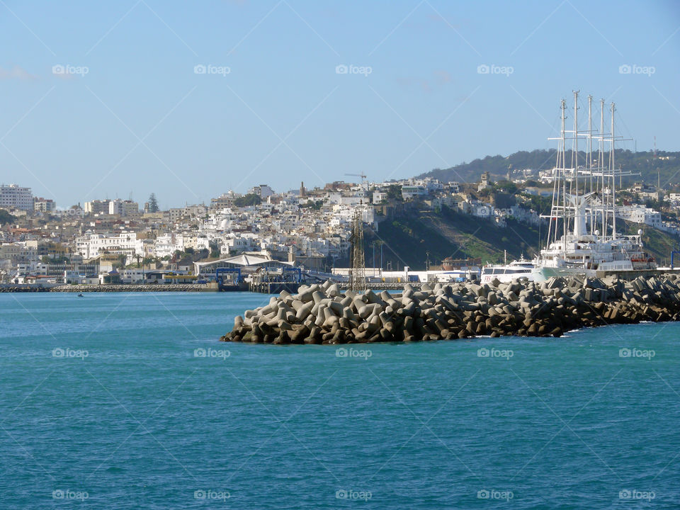 Scenic view of port against cityscape.