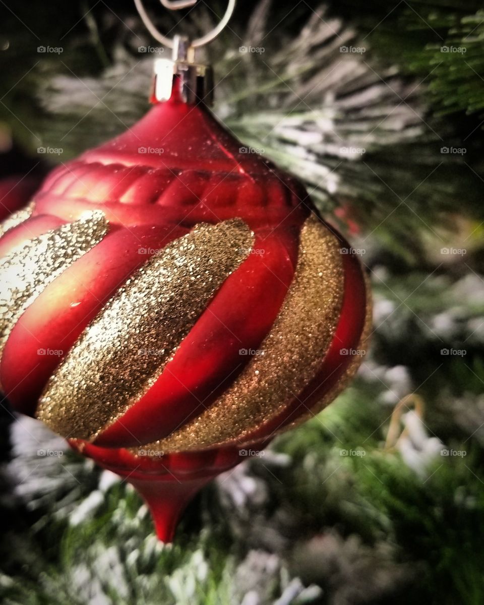 Christmas Ornament hanging on the green pine tree showing off red and gold colors to help us be festive and hopeful have cheerful. Make someone else feel the love ❤️ of the holidays too.