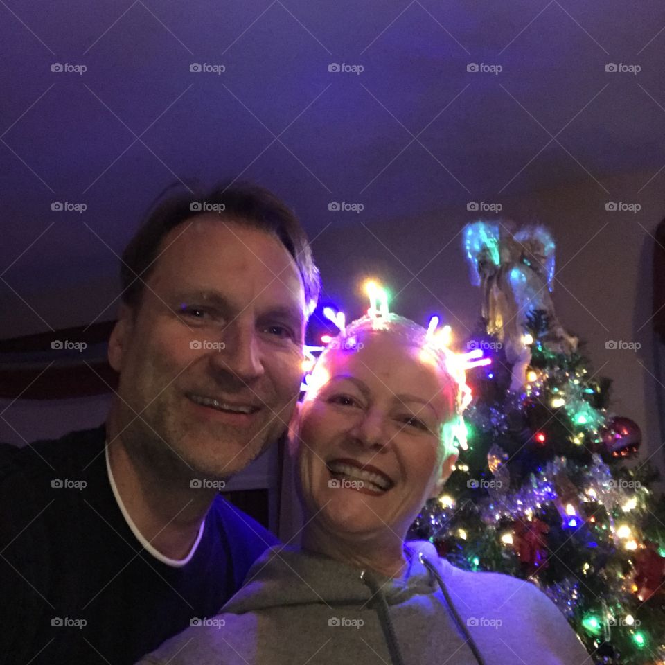 Portrait of a smiling couple against christmas tree