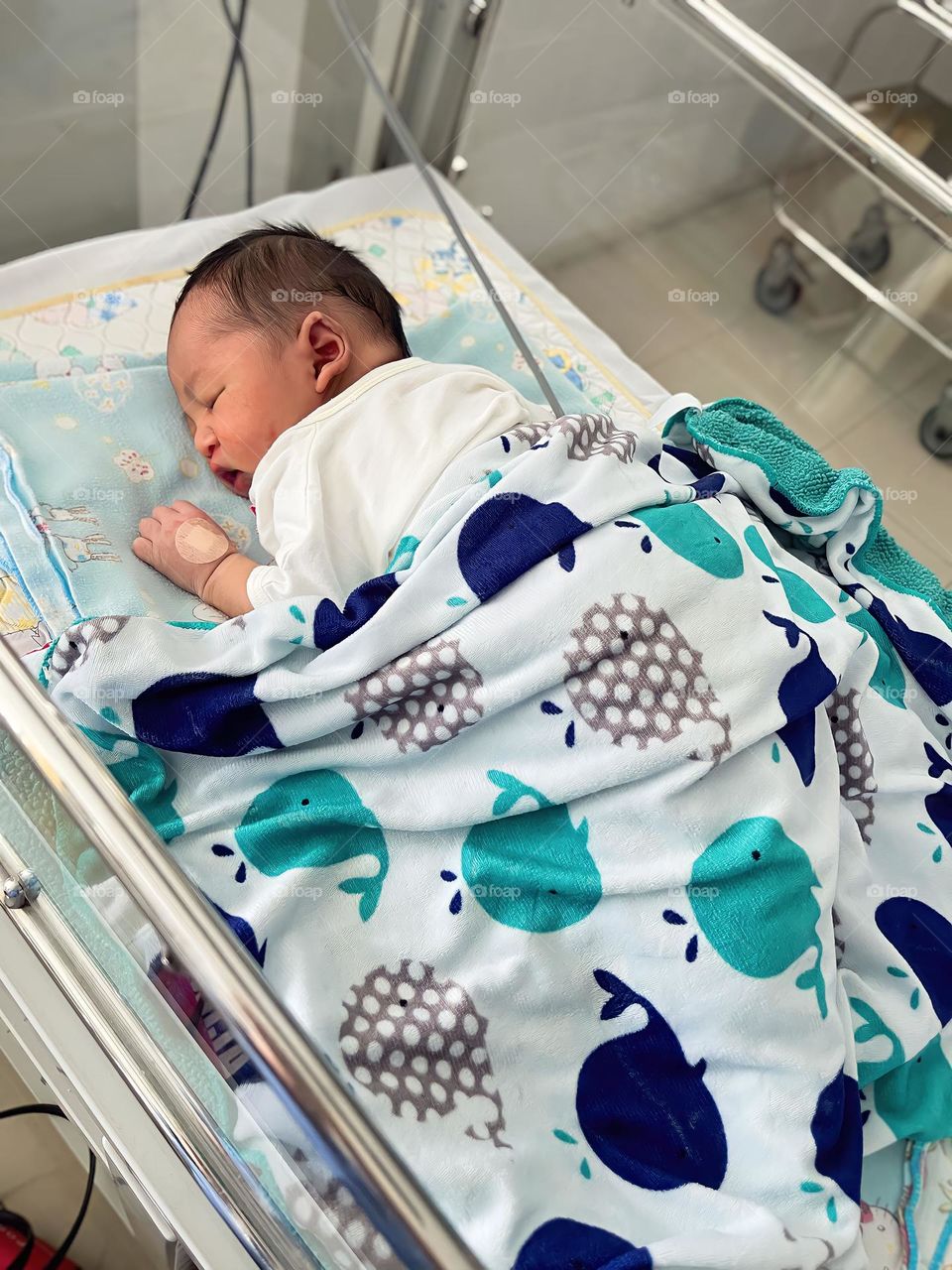 High angle view of baby boy lying on bed at hospital