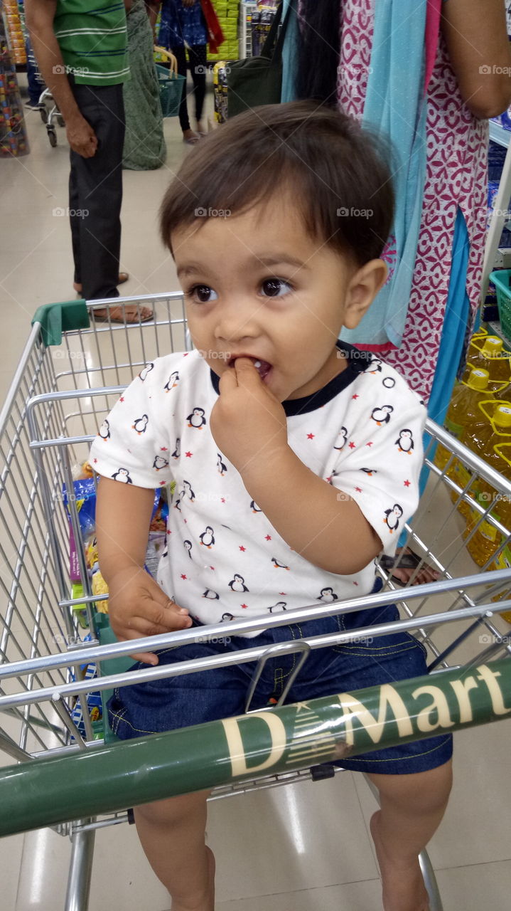 small baby enjoying in basket in a mall