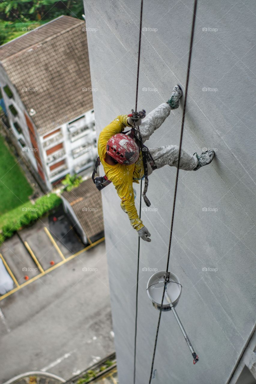 Worker abseiling down the side of a tower block in Kuala Lumpur Malaysia