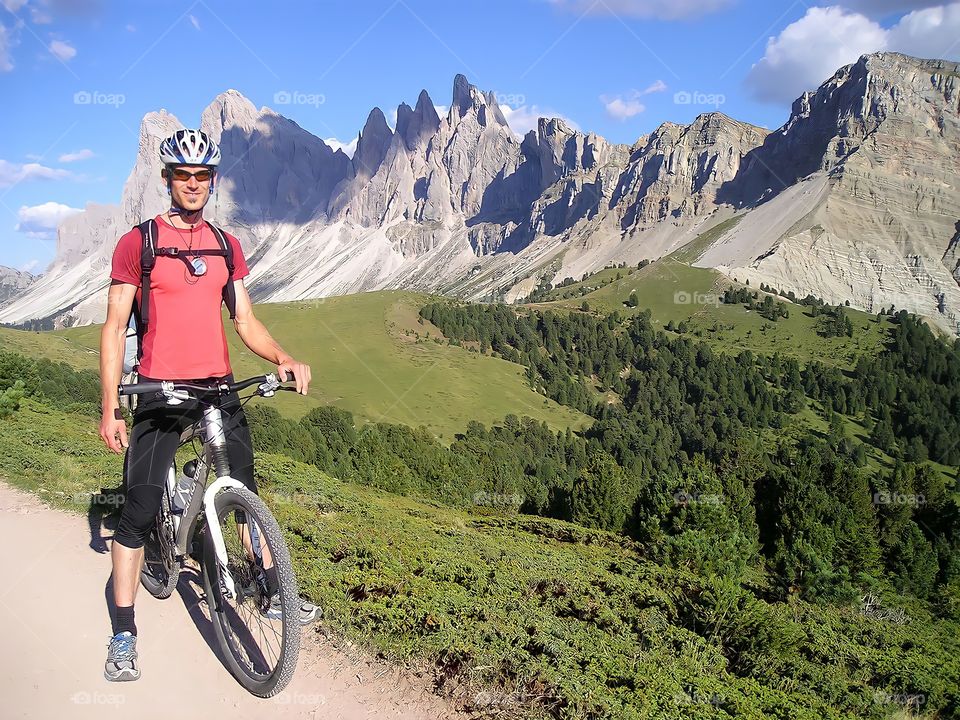 He smiles as he takes a photo with a spectacular view of the French-Catalan Pyrenean mountain ranges on a great day of mountain biking.